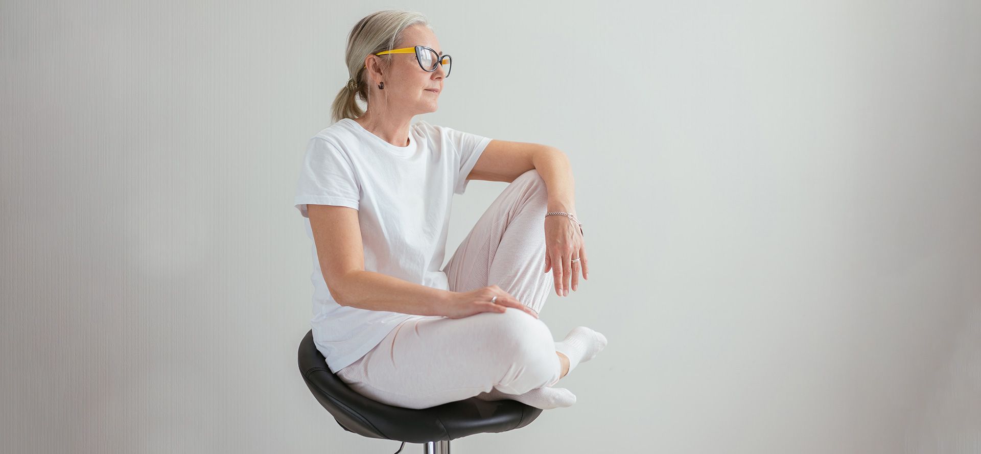 Femme de plus de 40 ans assise sur une chaise.