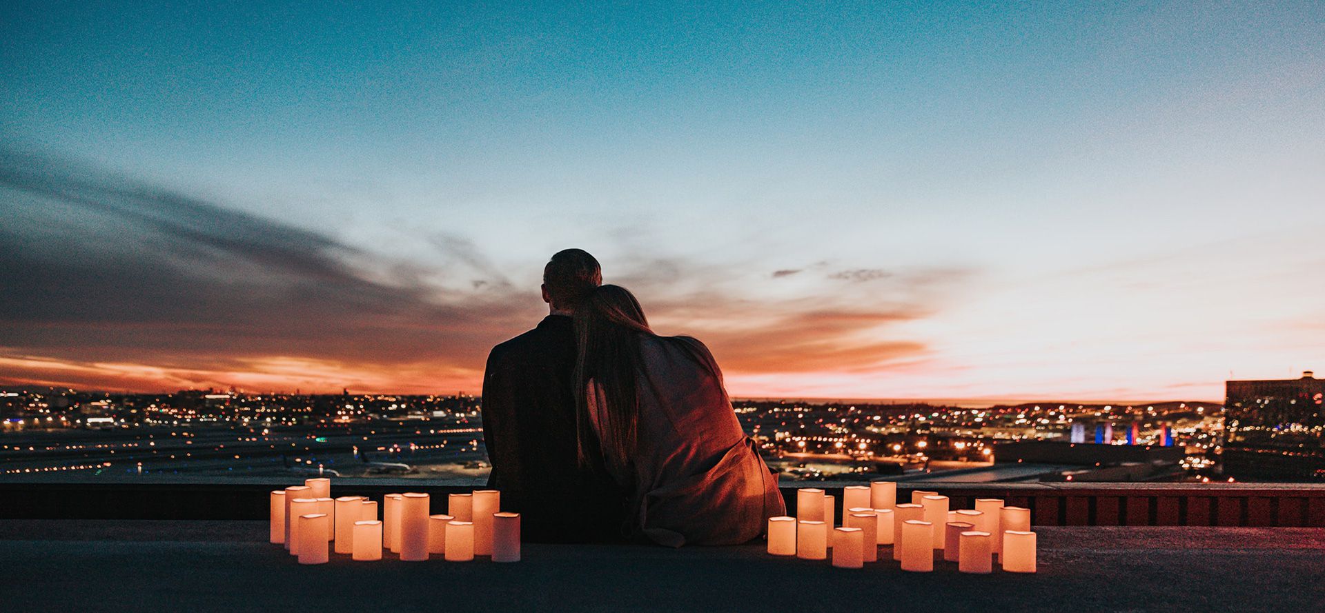 Couple sitting on the roof at sunset.