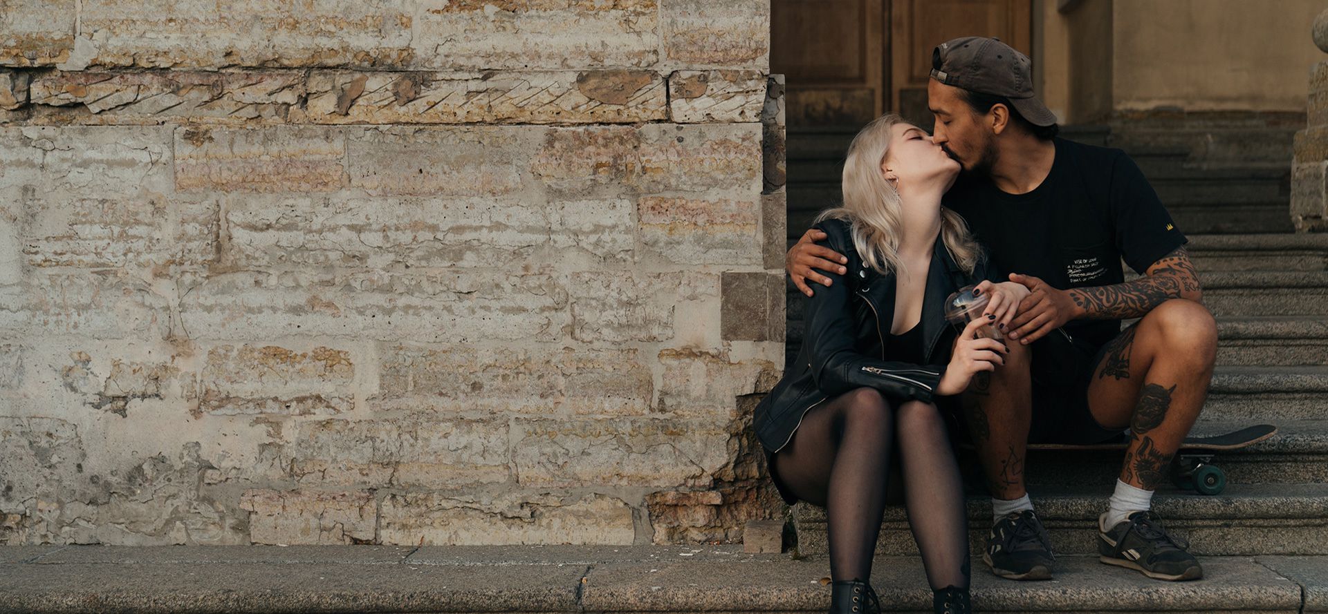 A man kisses a blonde woman.