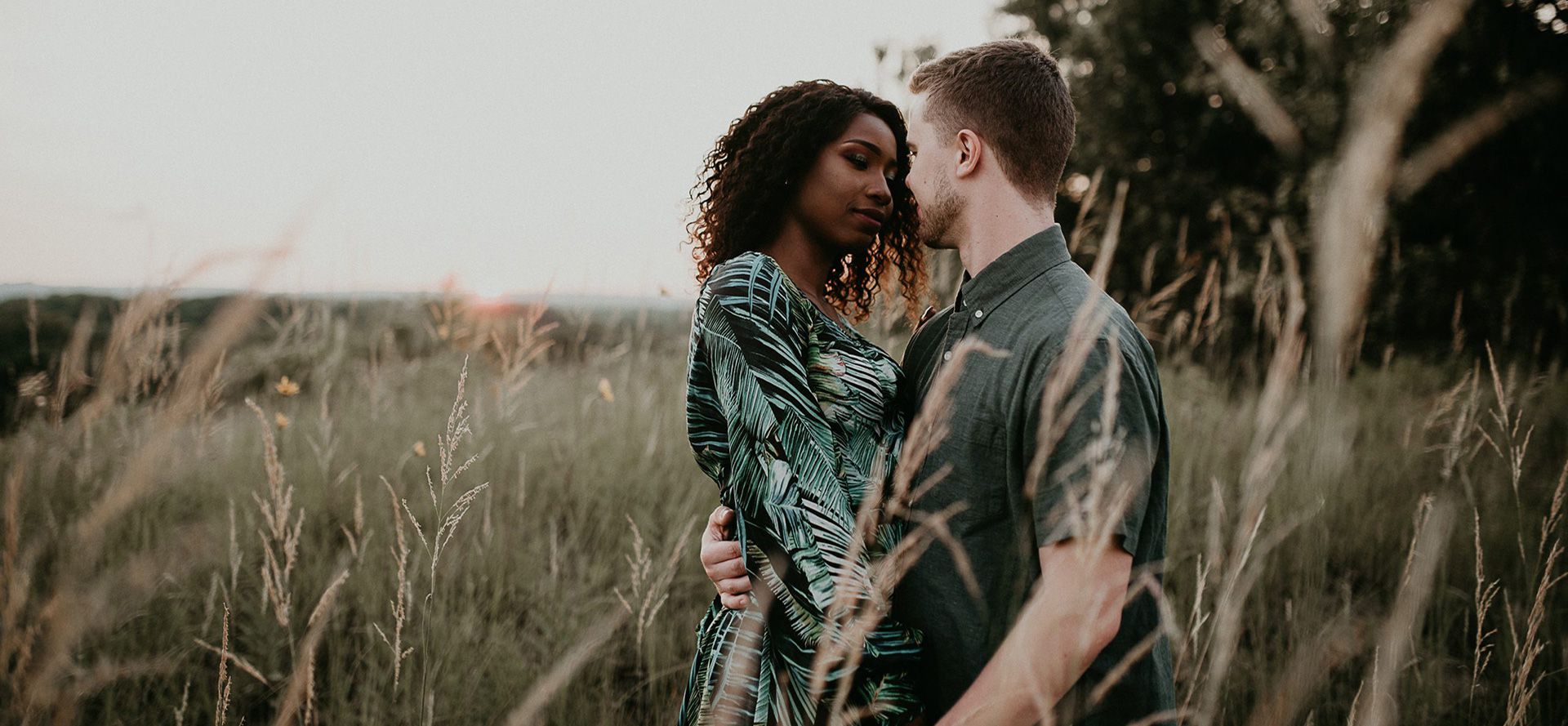 Homem branco e mulher negra no campo.