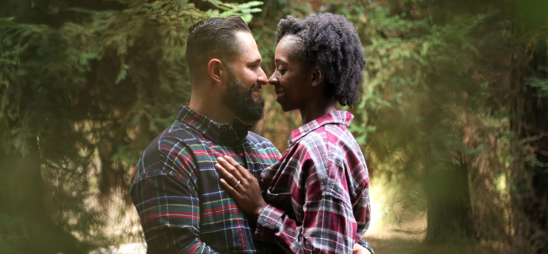 White man and black woman on a date in the forest.