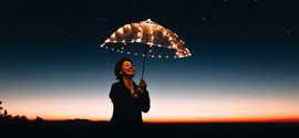 A woman at night with umbrella.