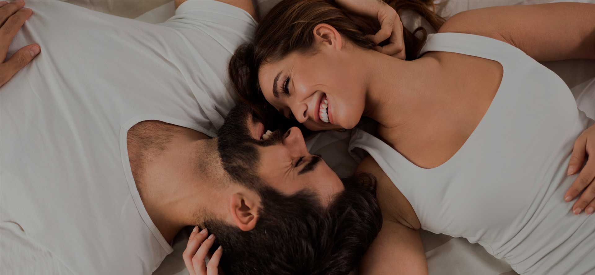 Mies ja nainen makaavat ja nauravat.