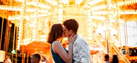 Kissing on the Background of the Carousel.