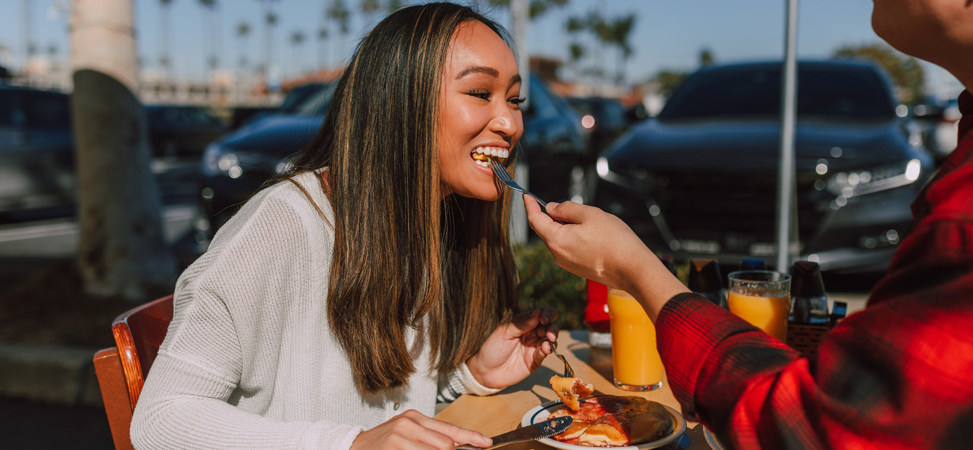 A man feeds a woman on a date.