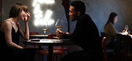 Pariskunta romanttisilla treffeillä ravintolassa juomassa viiniä.