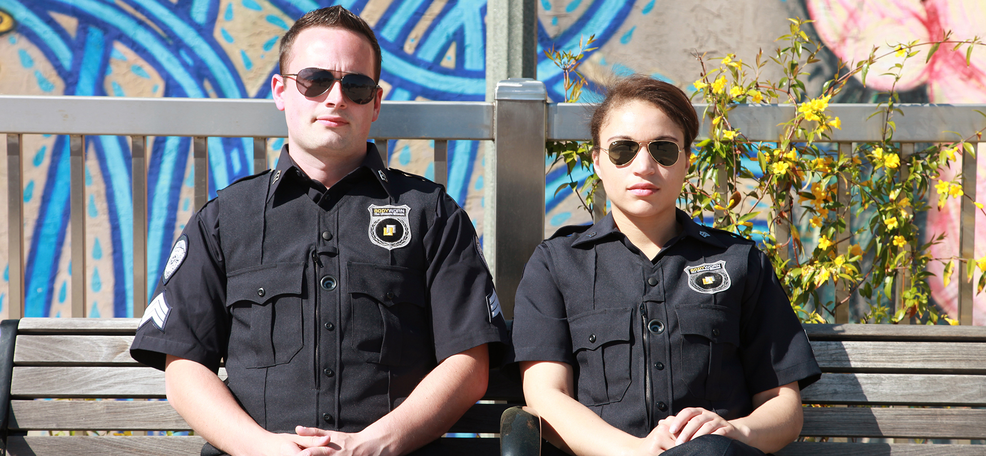 A couple of cops are sitting on a bench.