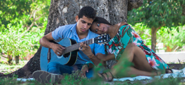 Una pareja latina con una guitarra en una cita romántica.