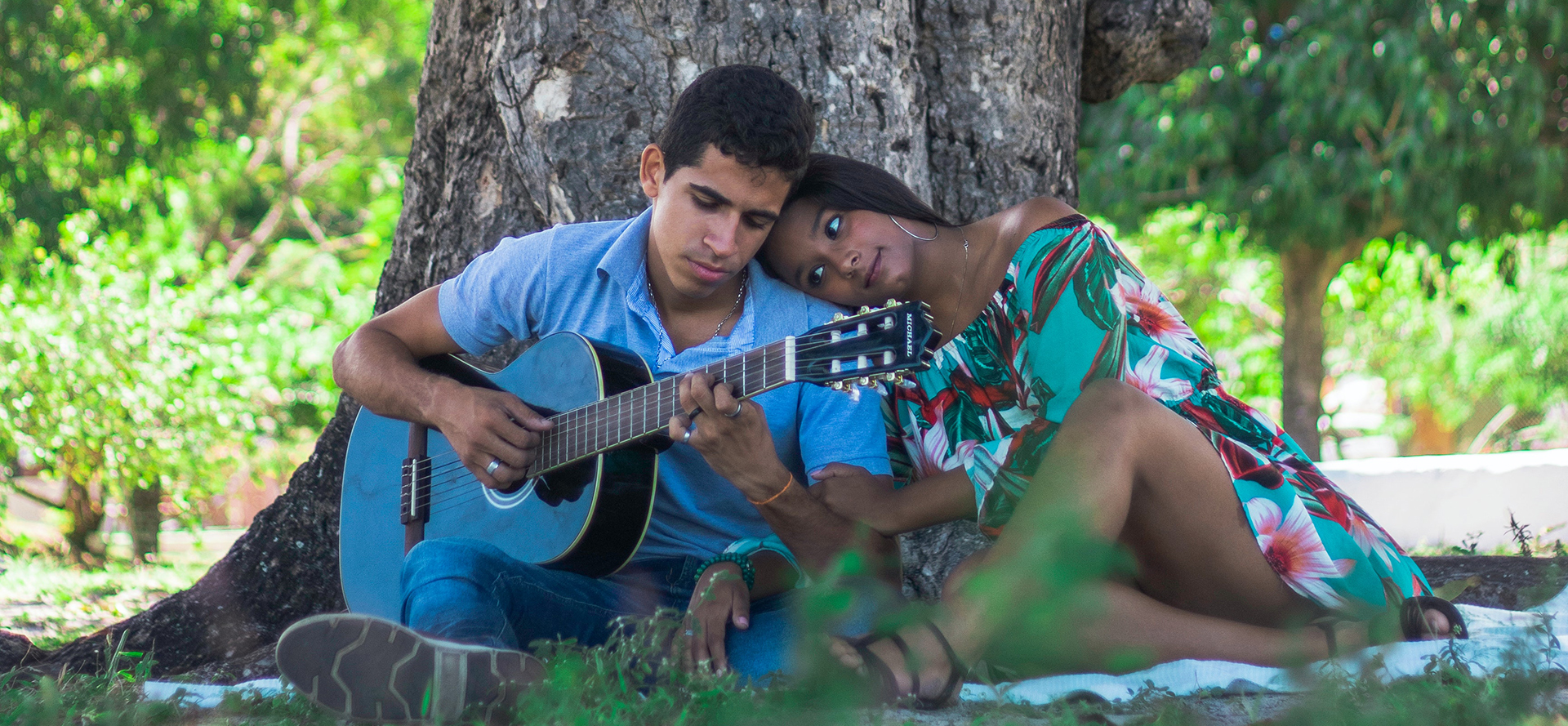 Ein lateinamerikanisches Paar mit einer Gitarre bei einem romantischen Date.