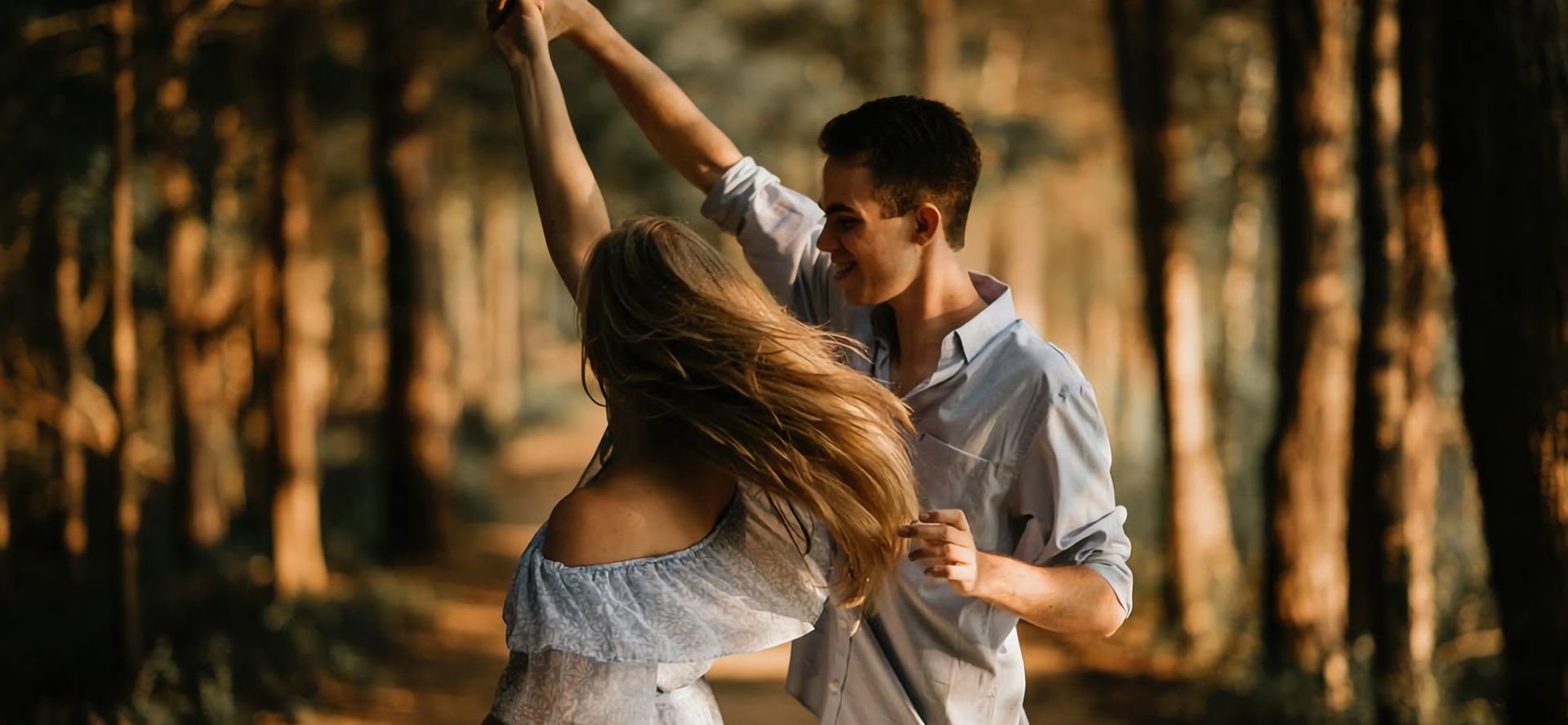 A couple in love dancing in the woods.