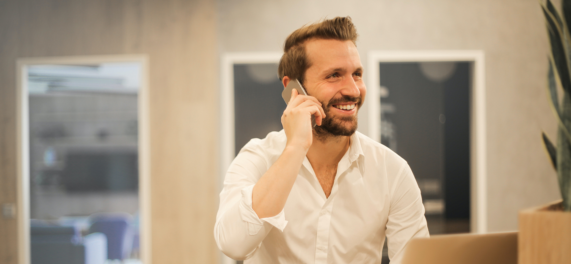 The executive man in a white shirt is talking on the phone.