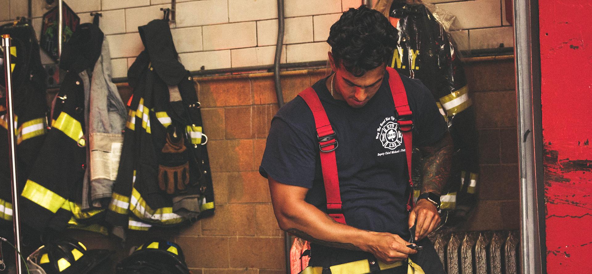 The firefighter puts on his equipment.