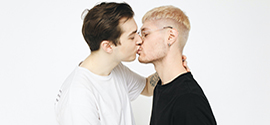 Ett homosexuellt par kysser varandra.
