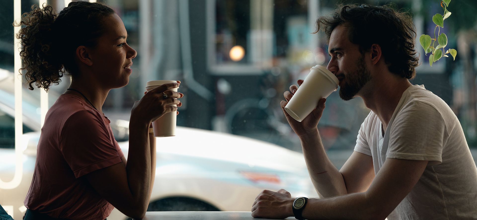 A couple drinking coffee in a cafe on their first date.