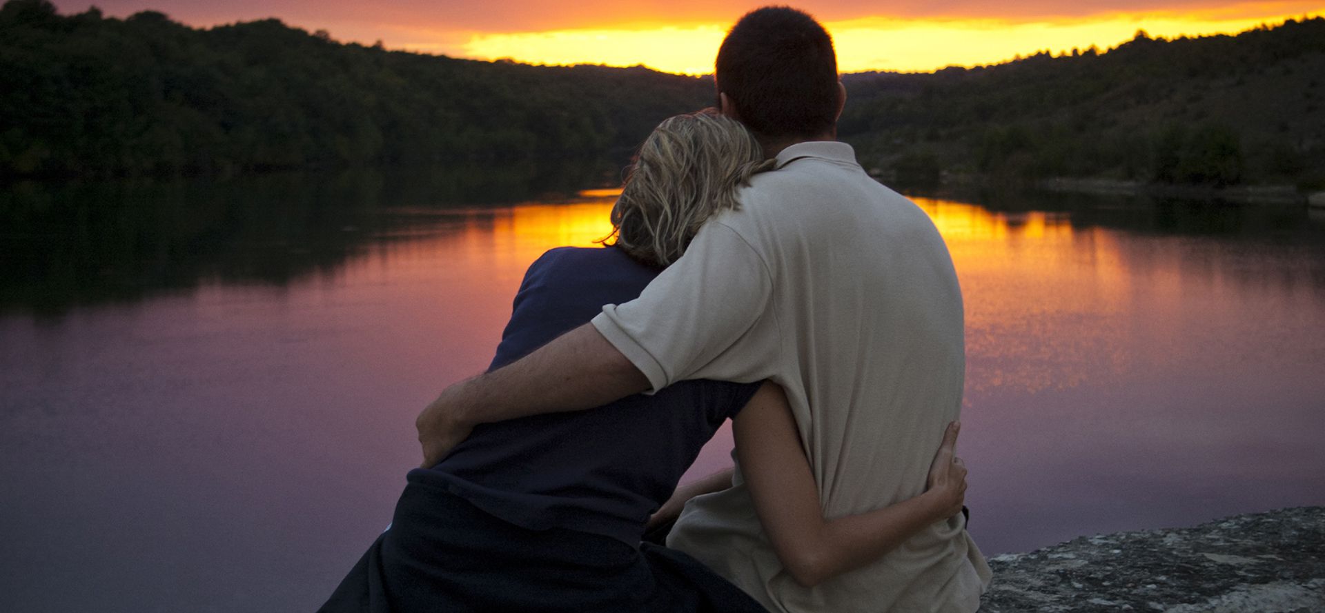 Couple hugging at sunset.