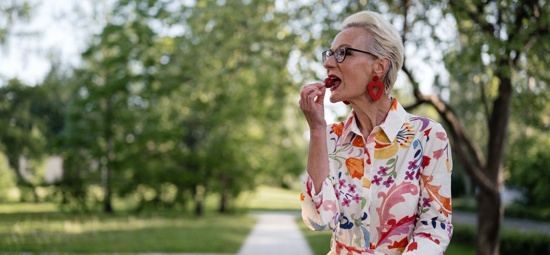 Older woman eat strawberry.