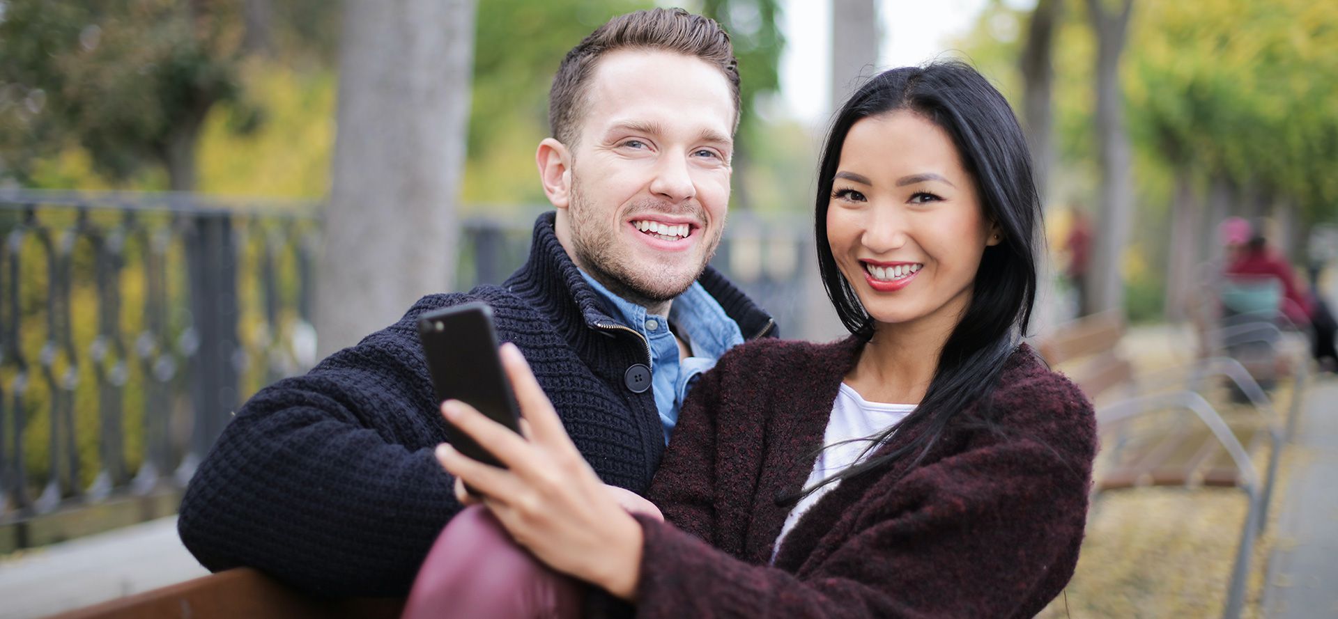 Couple international assis dans le parc.