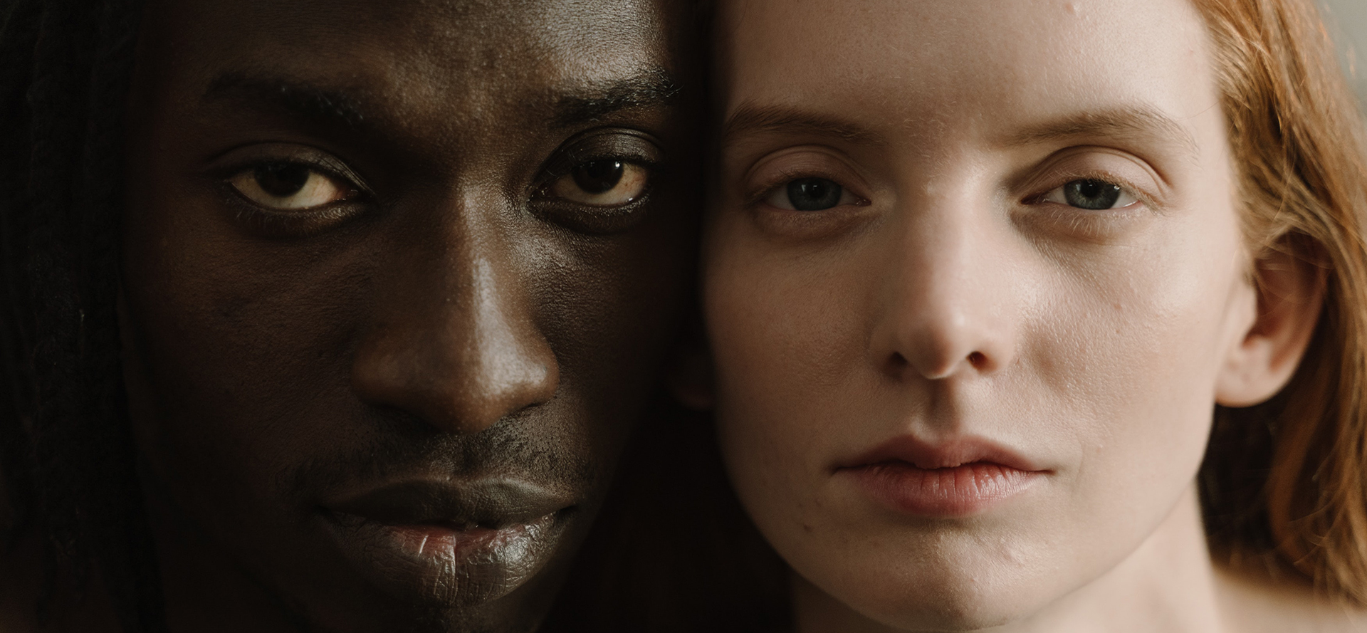 Um retrato cara a cara de um homem negro e de uma mulher branca.