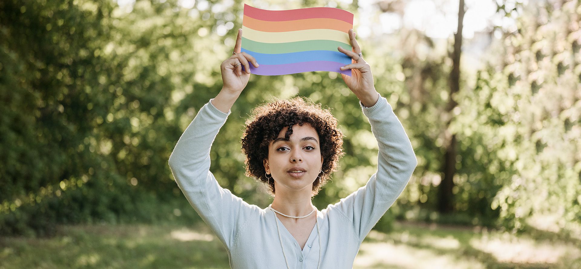 Mulher segurando uma bandeira LGBTQ.