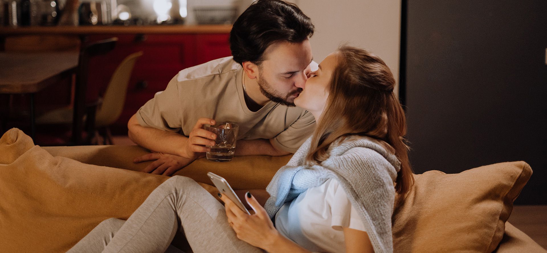 Pareja besándose en casa.