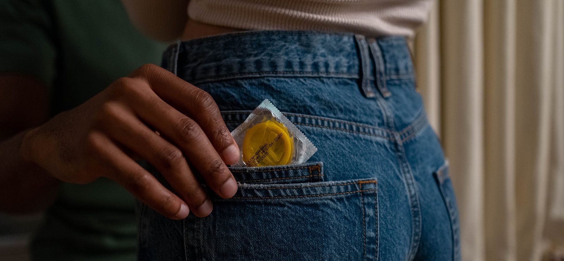 A man takes a condom out of pocket.