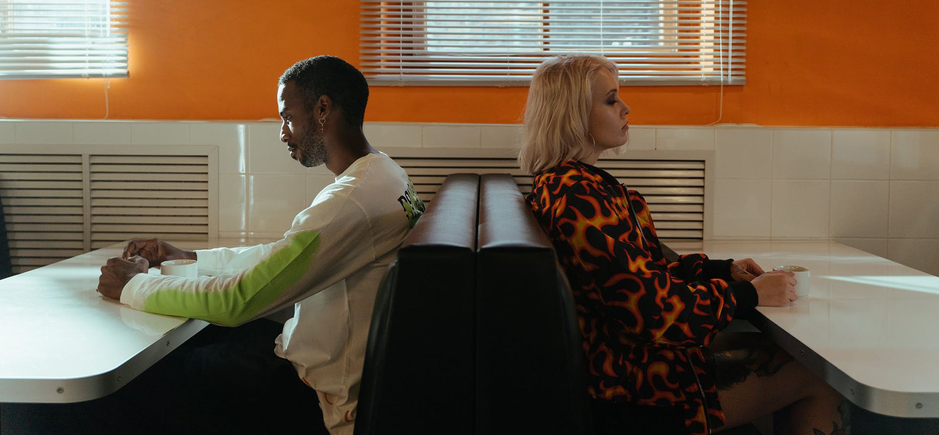 Man and woman sitting with their backs to each other.