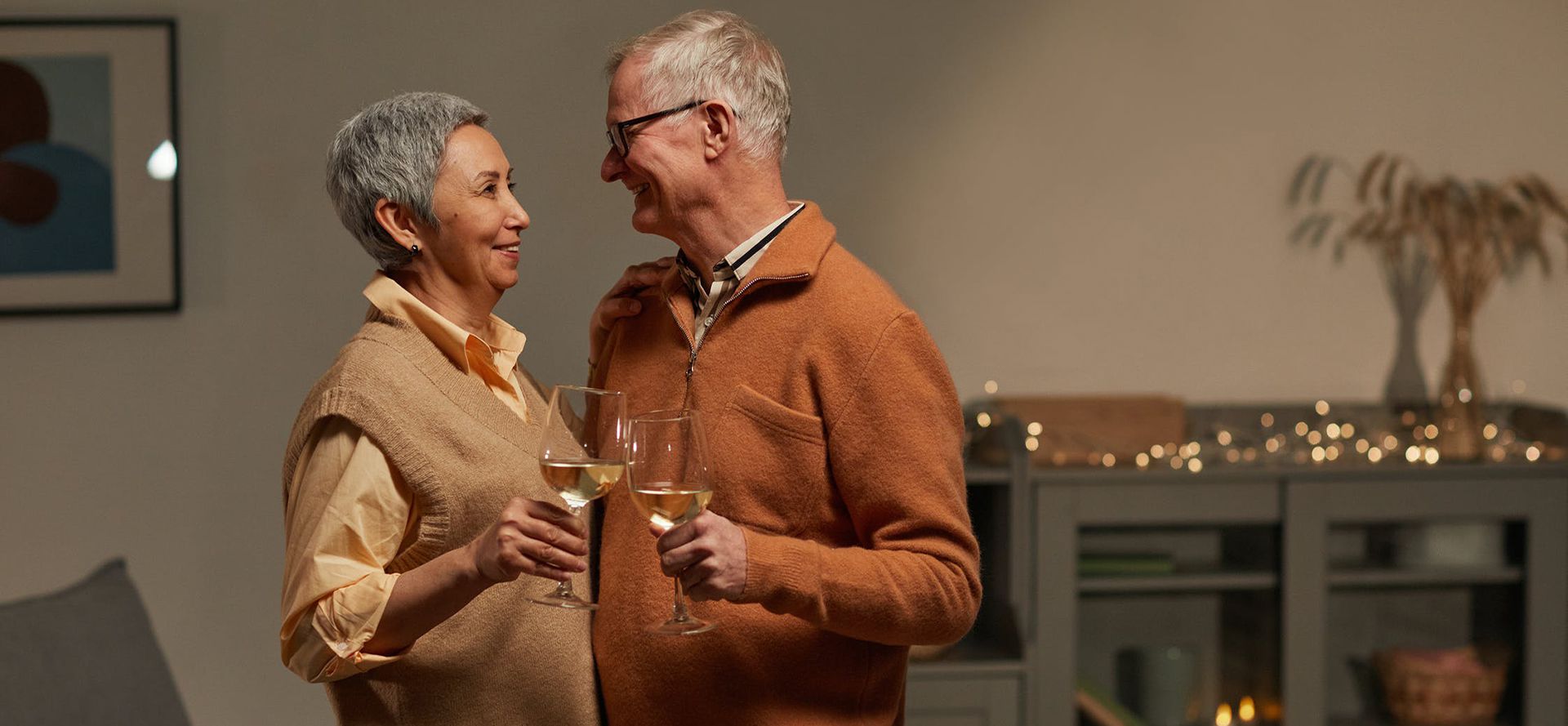 Personnes âgées dansant avec un verre à vin lors d'une rencontre.
