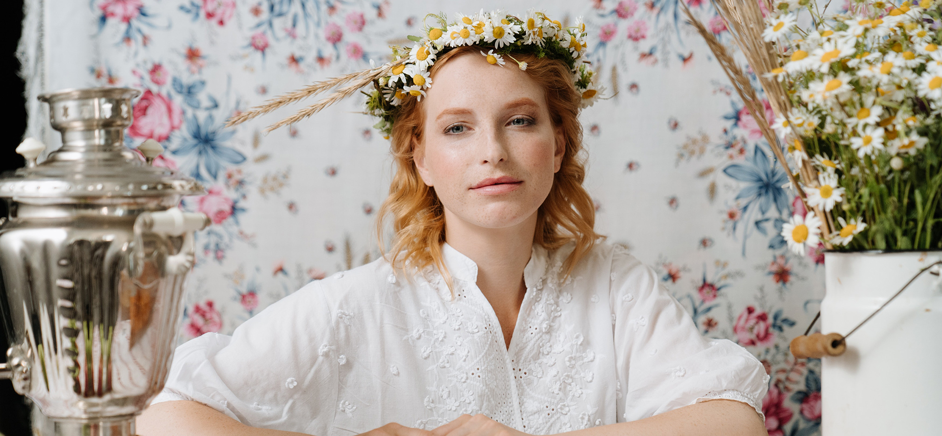 Une belle femme russe avec une couronne de camomille sur la tête.