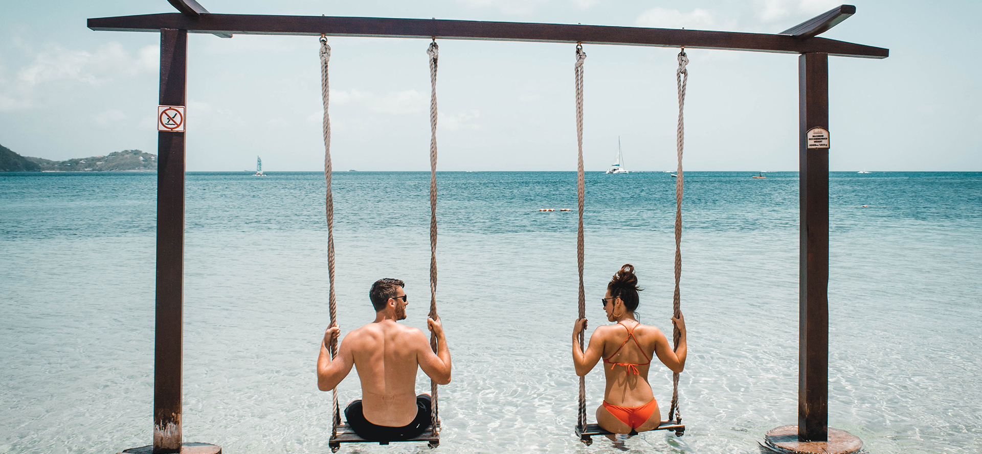 Pareja samoana balanceándose en un columpio.