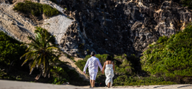 Casal samoano em um encontro caminhando ao longo da praia.