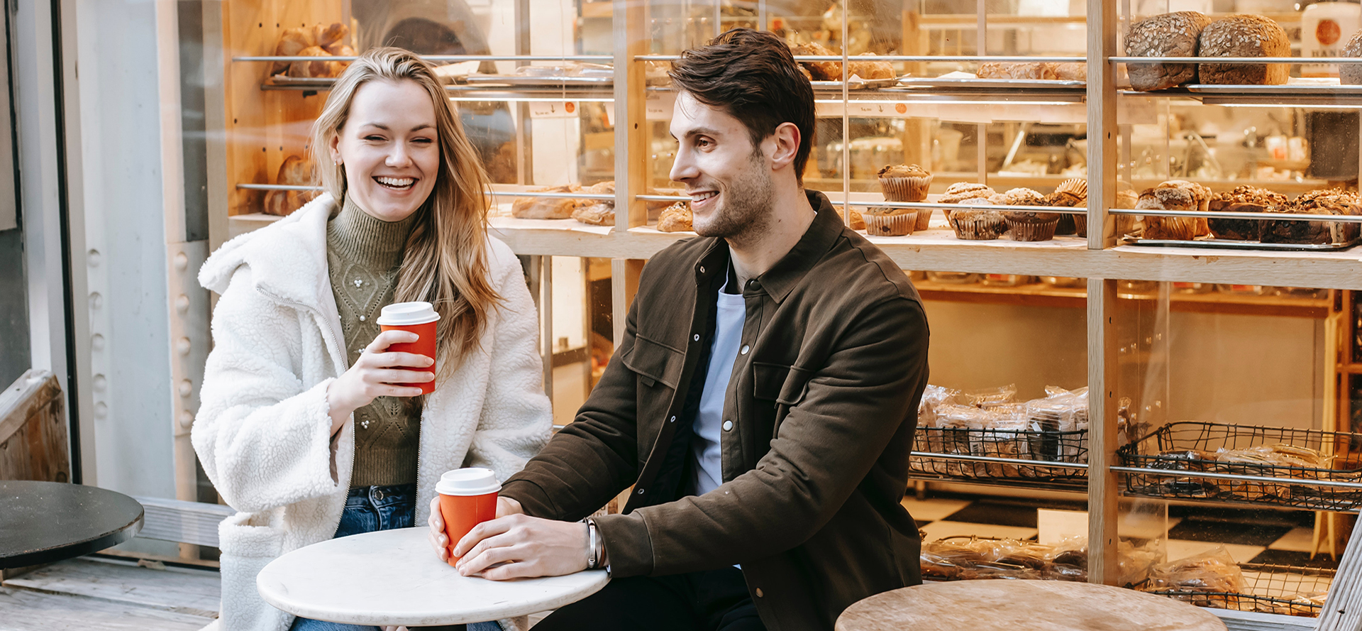 Sober singles on a date are drinking coffee and laughing. 