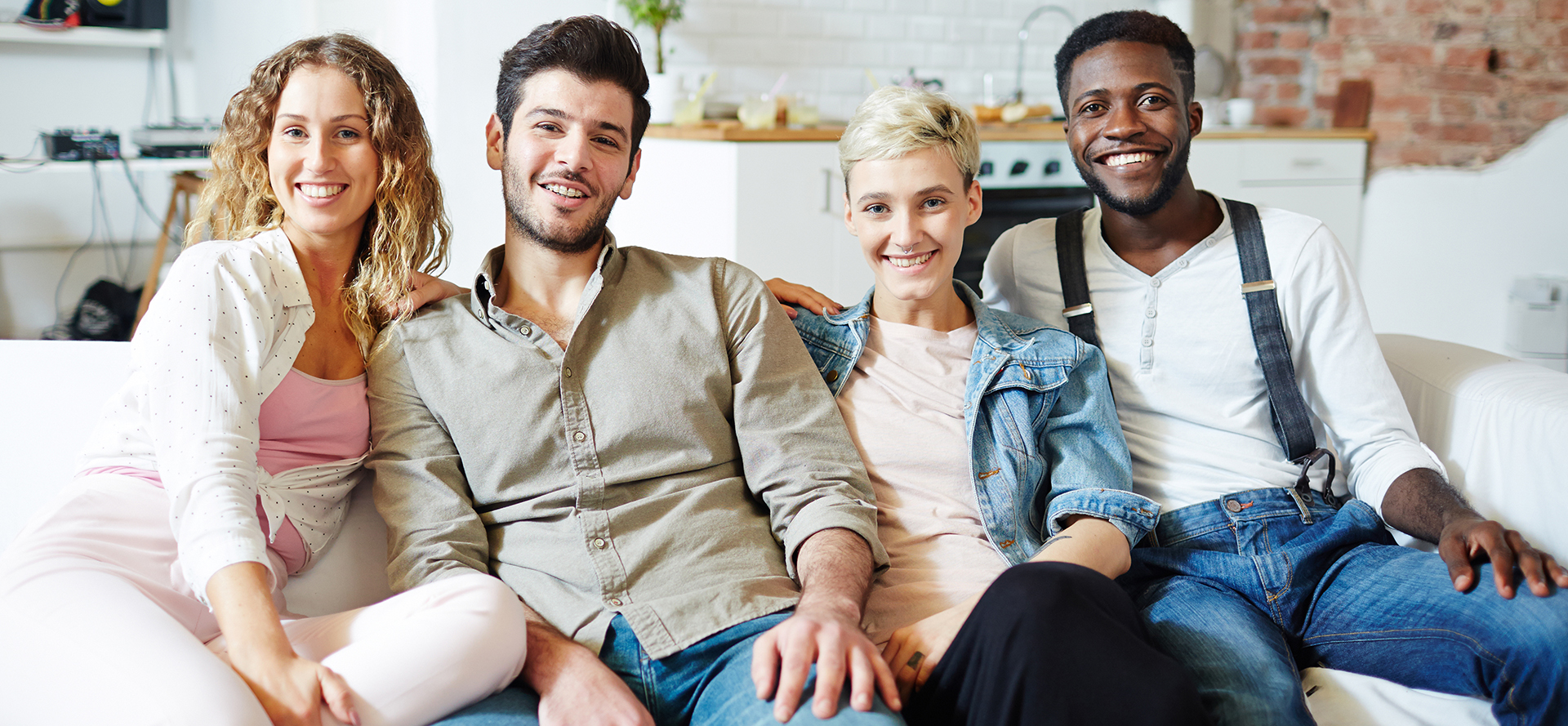 Swingers seated on a white couch.