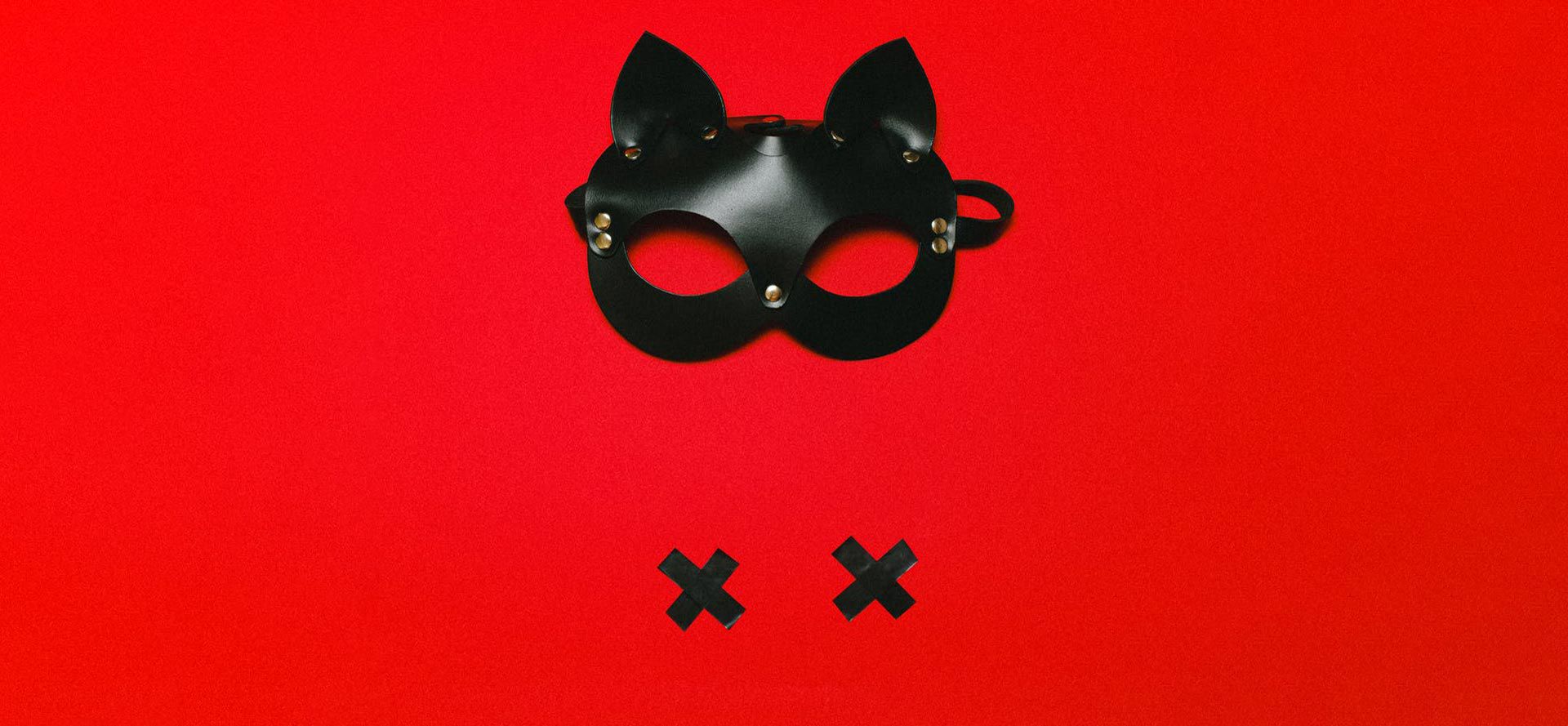 BDSM mask on a red background. Date.