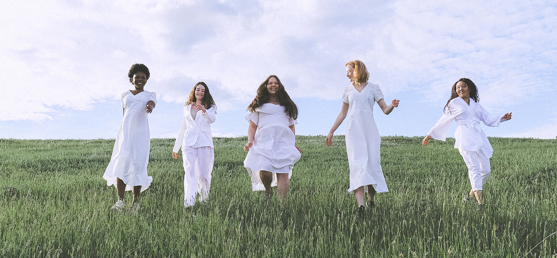 Girls in a white dress running across the field.