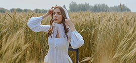 A virgin girl in a white dress in the field.